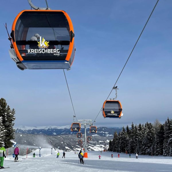 Seilbahn am Kreischberg mit Blick auf eine Skipiste, die bergab führt.